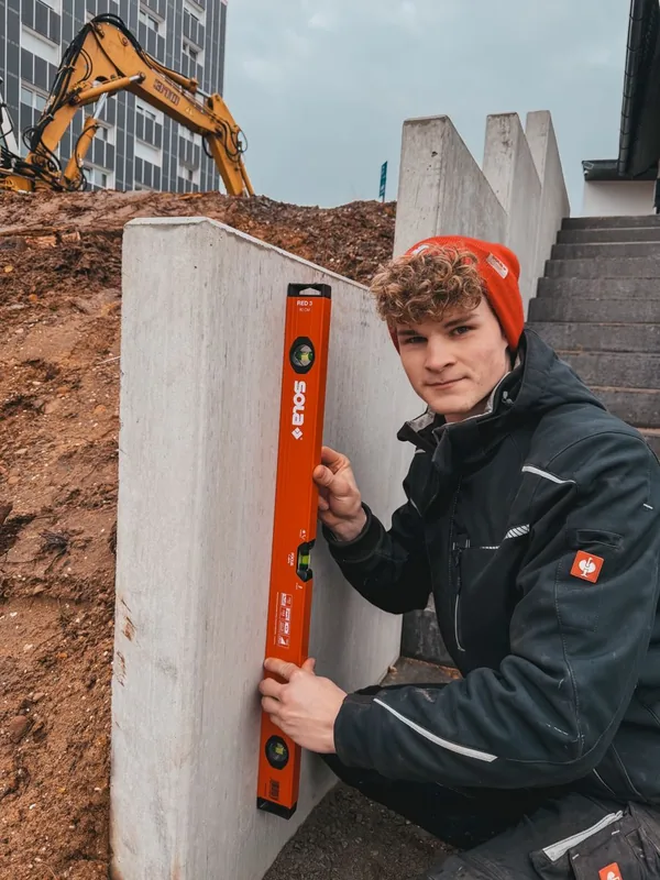 Mike mit Wasserwaage an einer Betonwand